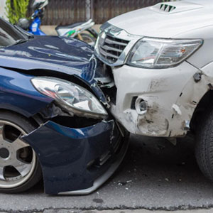 A damaged car after an accident, with a crumpled front end and shattered windshield