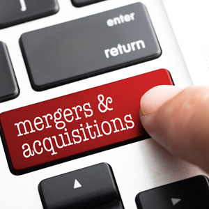Finger pressing "mergers & acquisitions" key on a keyboard.