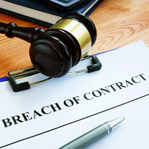 Gavel on a document indicating breach of contract.