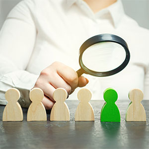 A magnifying glass examining a row of wooden figures, one of which is green, Misclassification-Claims